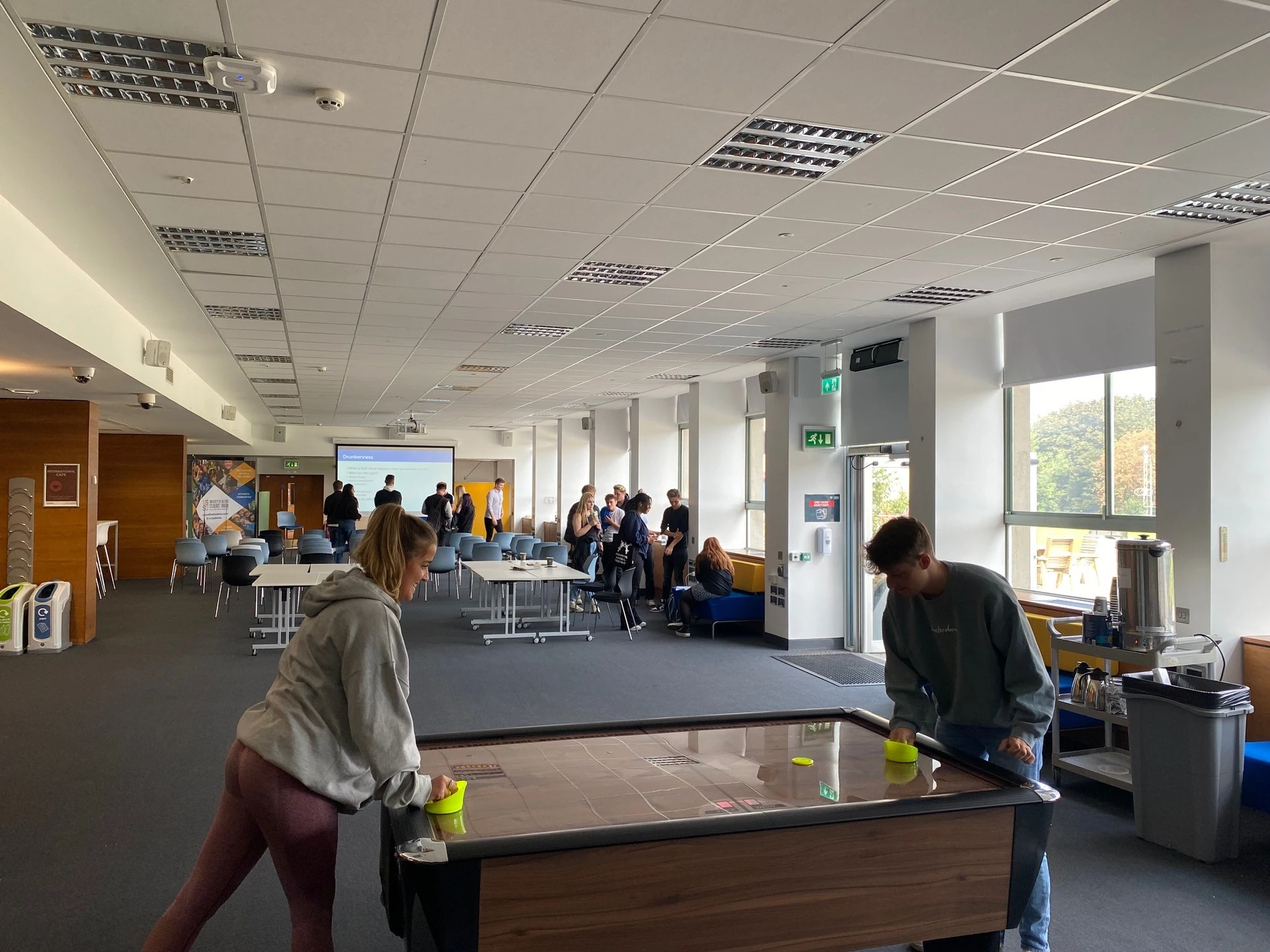 two students playing air hockey on a contactless air hockey table at uni