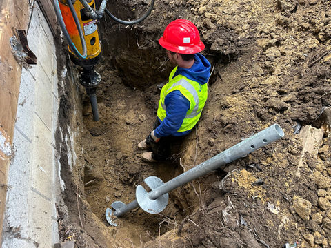 Calculus Foundation team member installing a helical pier