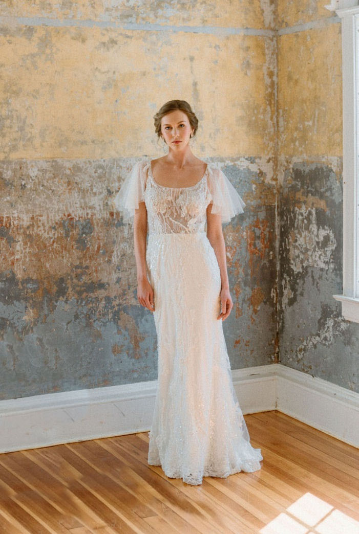 Front view of vintage inspired beaded sheath wedding dress with square neckline and tulle flutter sleeves