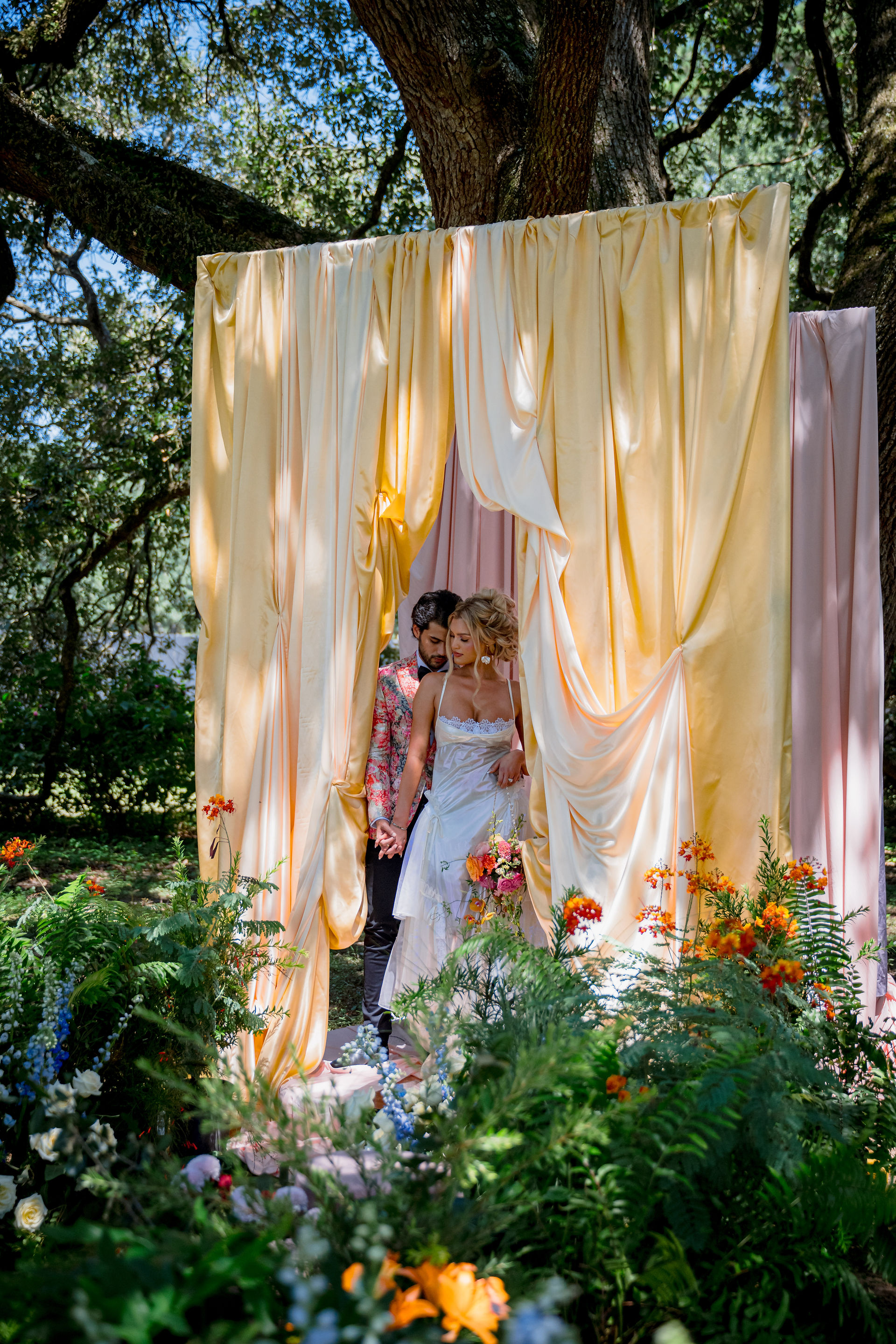 bride and groom at the ceremony with colorful courtins