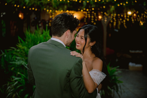 Close-up of bride and groom smiling while sharing a romantic dance outdoors