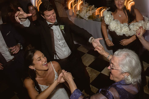bride and groom dancing with guests at their reception.