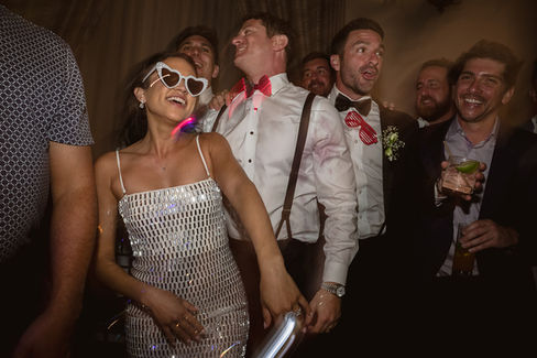 Bride dancing in sunglasses surrounded by guests at Hotel El Convento
