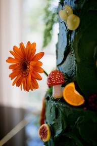 Green wedding cake Adorned with whimsical red mushrooms and displayed on a grand piano, the design stood out beautifully against the house’s classic architecture.