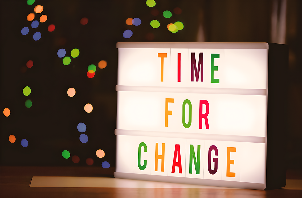 Photograph of a back lit sign that reads "time for change" in bright colours.