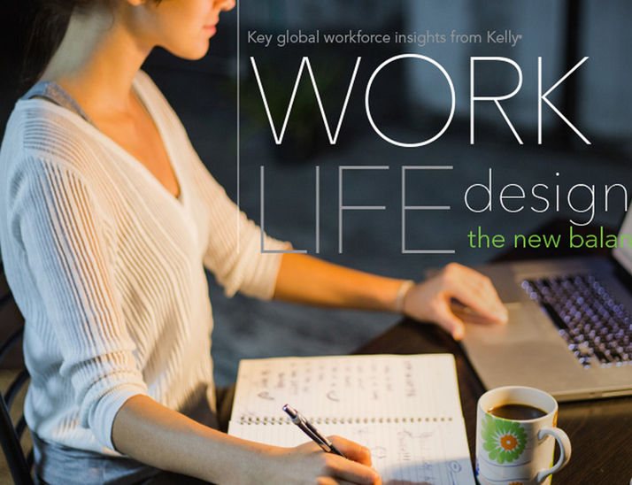 A woman sitting at a desk looking at her laptop and taking notes