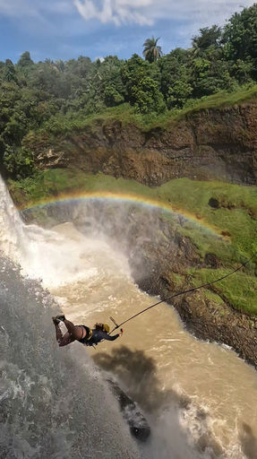 Salto na Cachoeira da Fumaça, com um arco iris ao fundo
