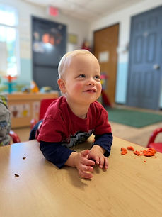 Infant enjoying tummy time and developmental play at Bright Minds Children Academy daycare in Aurora.