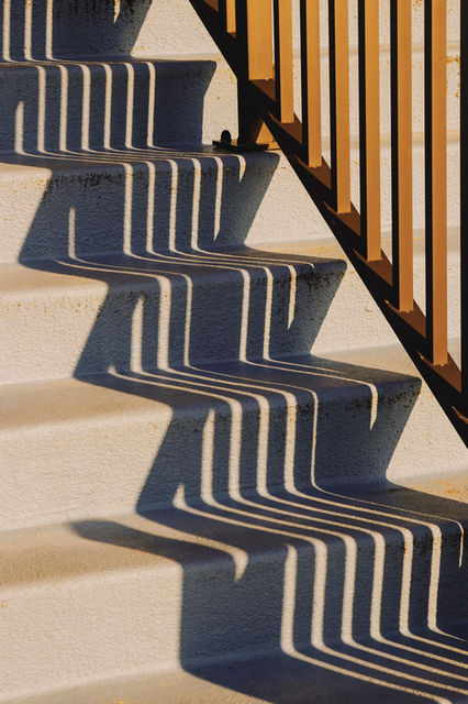 shadow of railing casts over steps. 