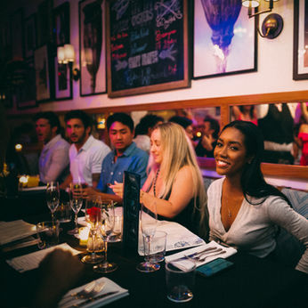 several friends sitting at a booth seat at cucina