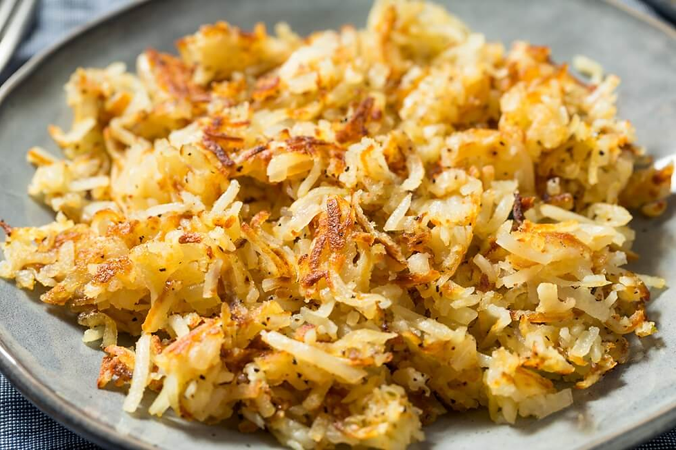 Close-up of crispy golden hash browns on a gray plate, with browned edges and a warm, appetizing texture.