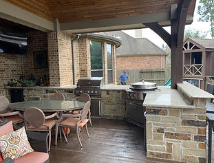Enviting back yeard living area with full hibachi grill, 42" Fire Magic grill and covered patio by DreamLife Custom Pools in Harmony Spring Tx