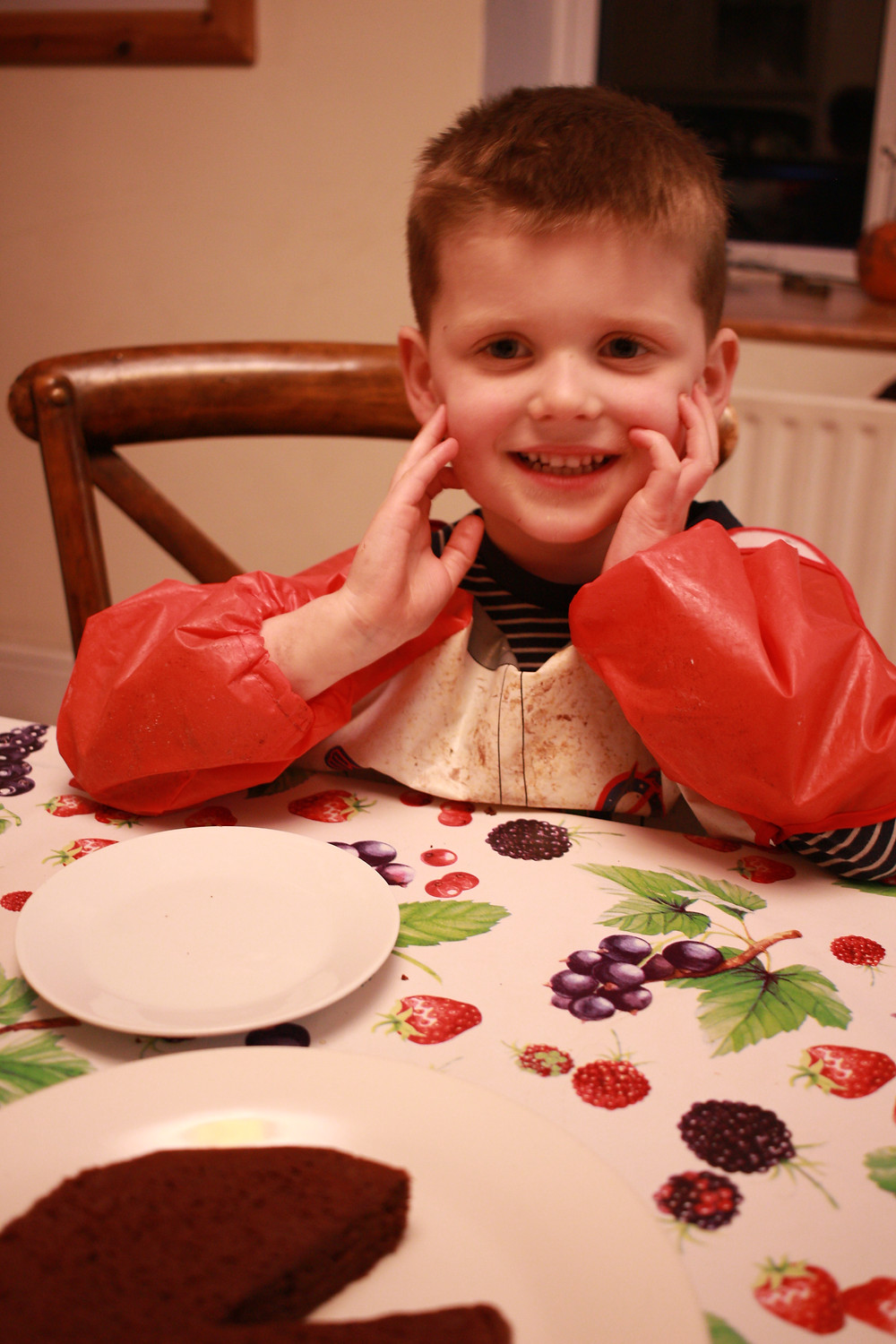 Happy boy eats slice of chocolate cake