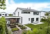Weißes Wohnhaus mit angelegetem Garten
