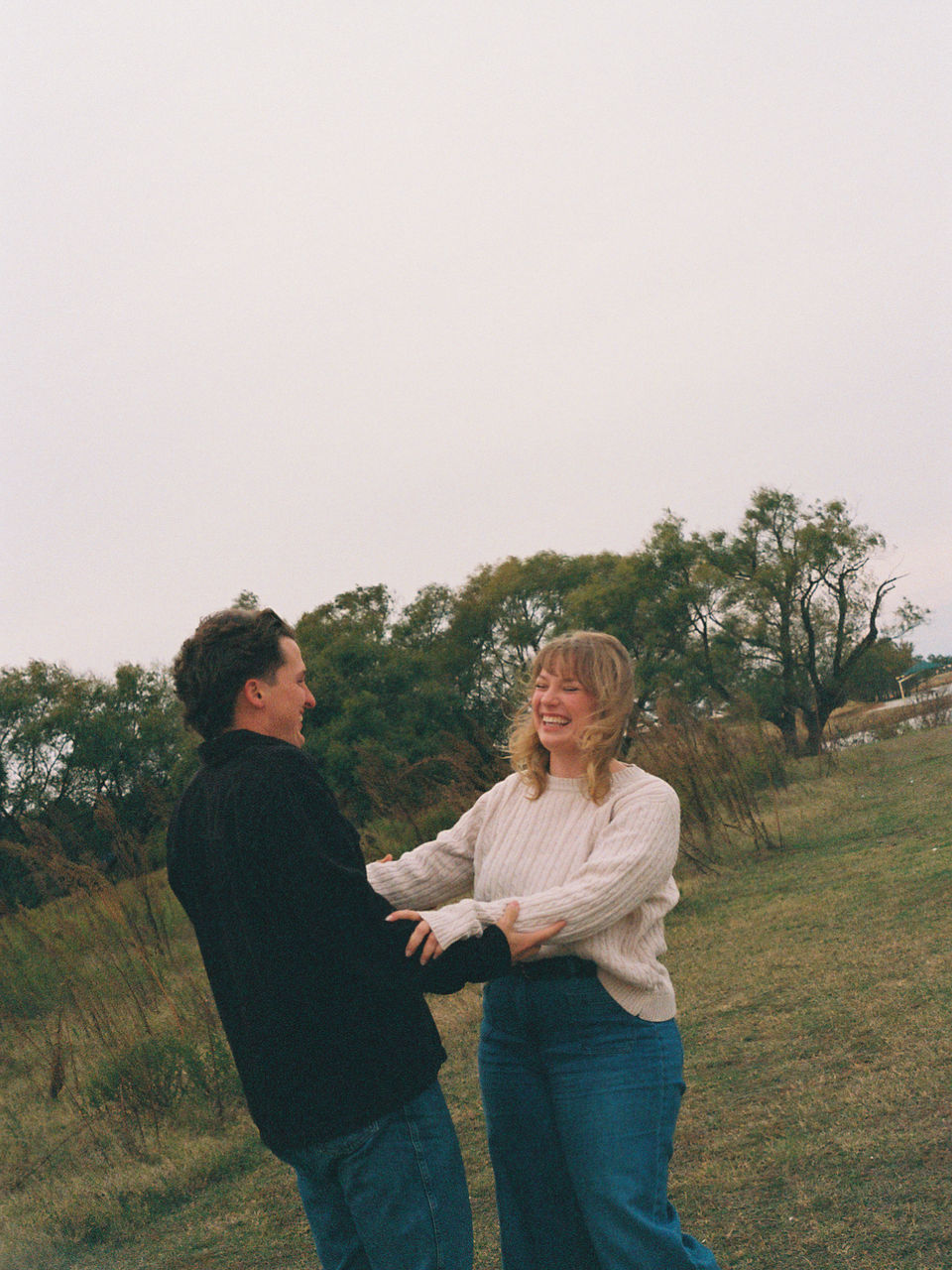 couple holding arms and laughing