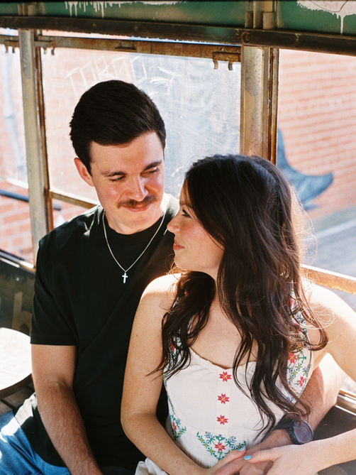 couple smiling in an old bus car, dallas photographer