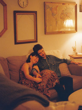 Husband and wife cuddled on a couch in their home