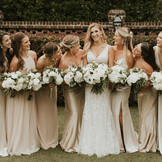 The bridesmaids looking at the bride and smiling for a photo.