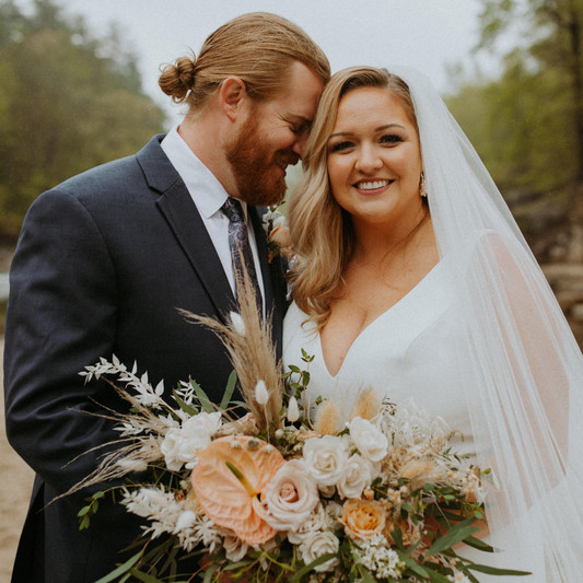 A husband and wife posing for a photo on their wedding day.