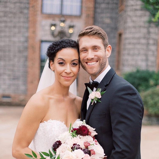 A couple posing for photos on their wedding day.