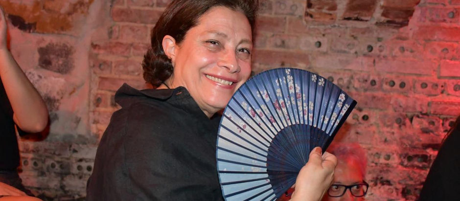  Retrato da escritora e poeta paranaense Marise Manoel sorrindo, com um leque na mão.