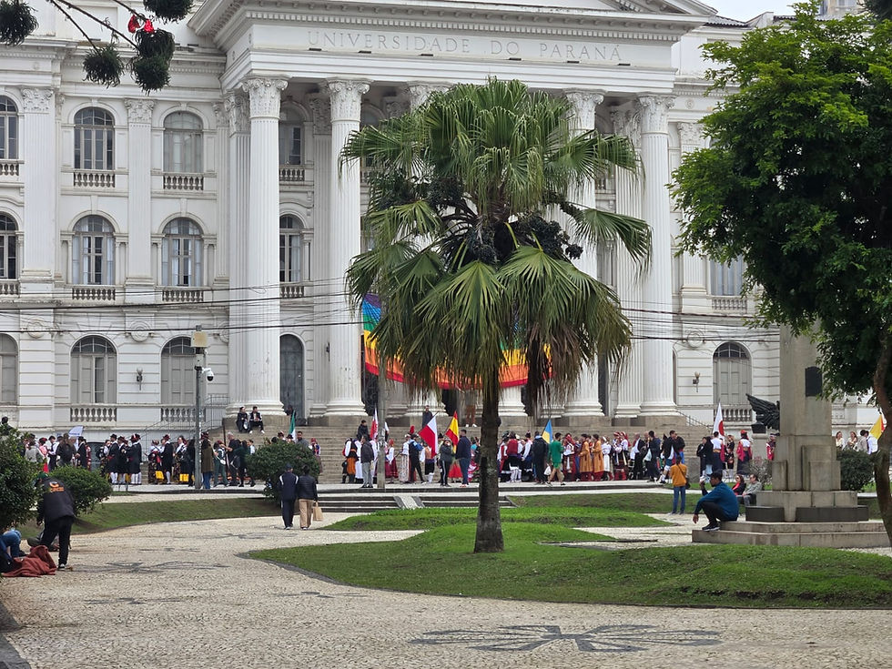 O imponente Prédio Histórico da UFPR, na Praça Santos Andrade, ornamentado com as cores do arco-íris para a abertura do desfile.