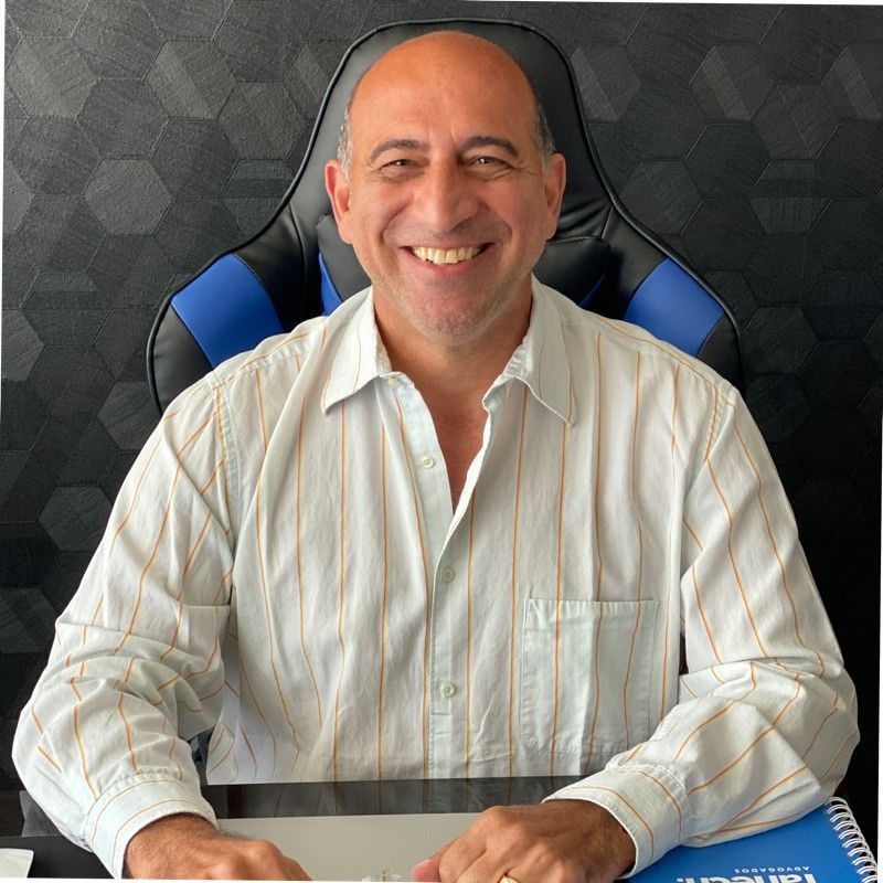 Retrato do advogado Jorge Tahech sorrindo em seu escritório, autor do relato Carta da América.