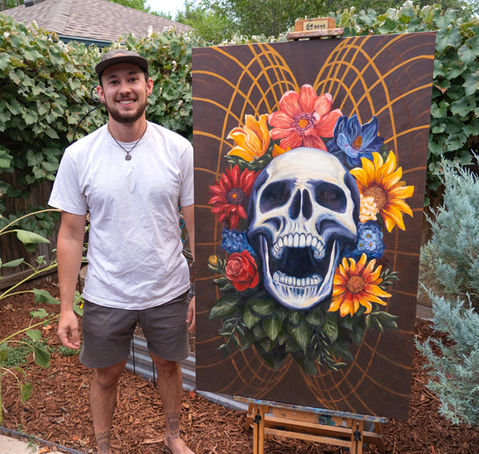 "Emergence" Oil Painting of skulls and flowers with artist standing next to it