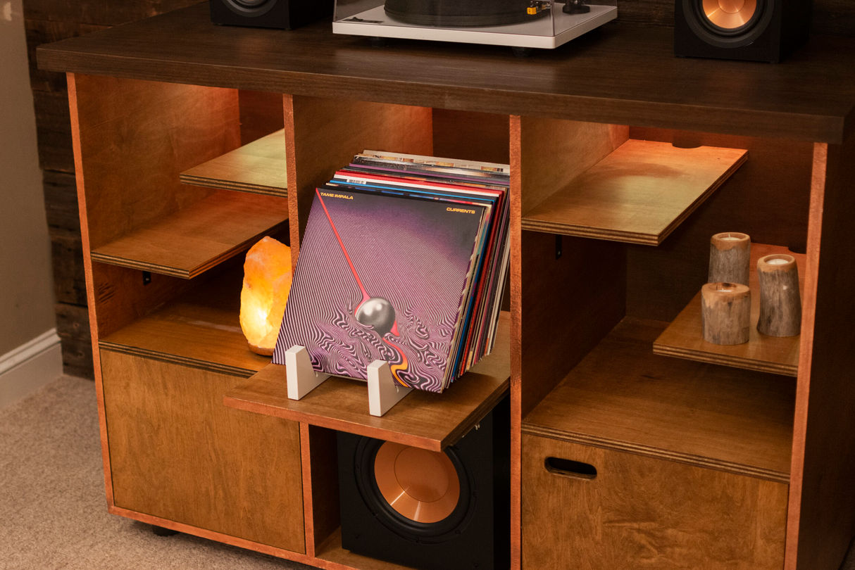 Detail view of hand crafted entertainment console featuring speakers, subwoofer, recessed lighting, and vinyle records