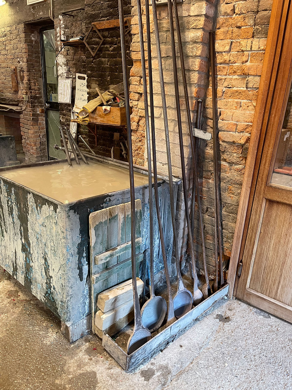 Giant steel spoons for stirring and ladling the molten glass