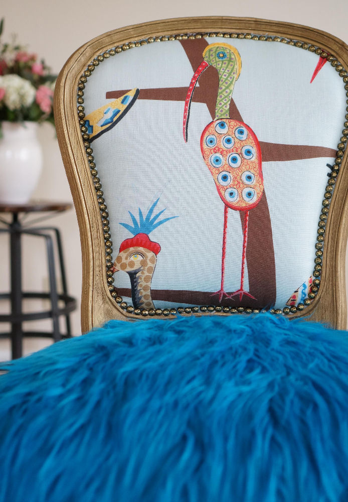 Playful funky blue bird French chair with blue faux fur, nailhead trim, and a vibrant enchanted forest design on the back.