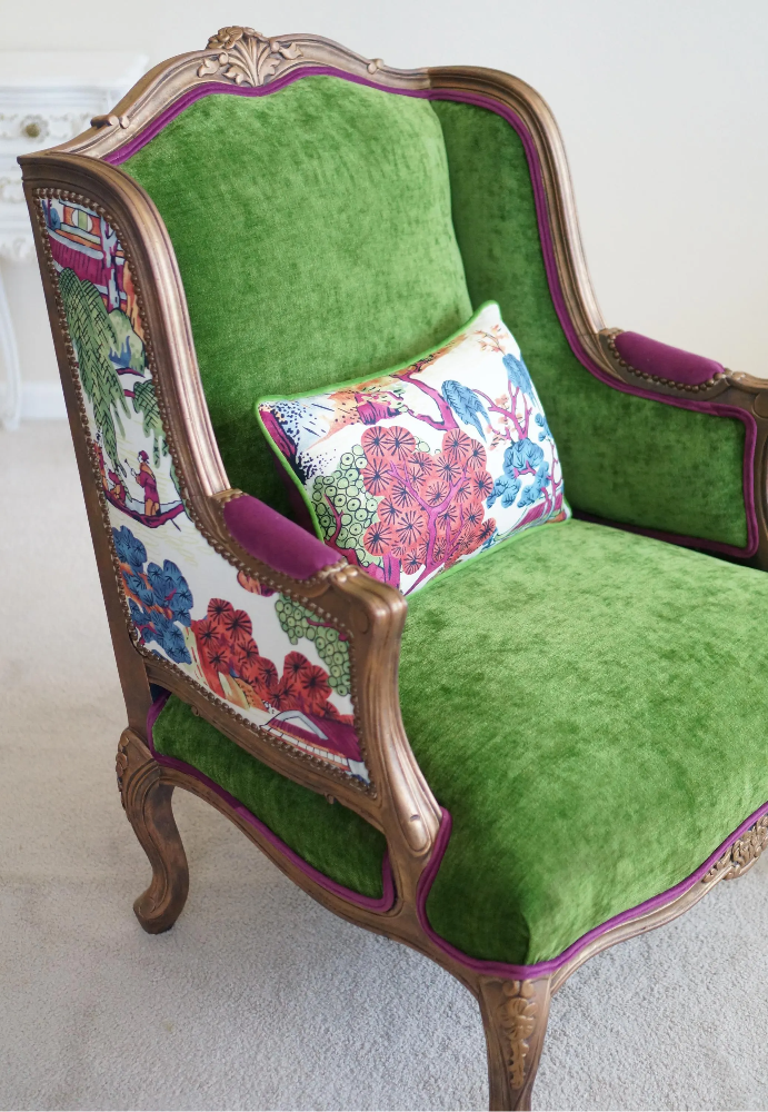 Elegant Chinoiserie French Bergere chair. Thibaut print back, green velvet seat, fuchsia trim, and antique copper gilding.