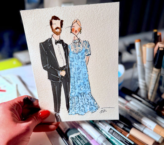 Hand holding fashion illustration of a couple in formal attire.