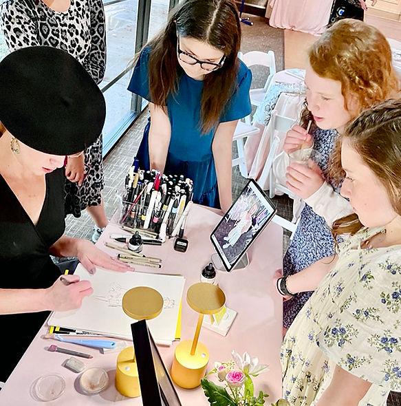 A Live event artist draws guests at a table to be given as bat mitzvah party favors, while surrounded by three girls watching intently. 
