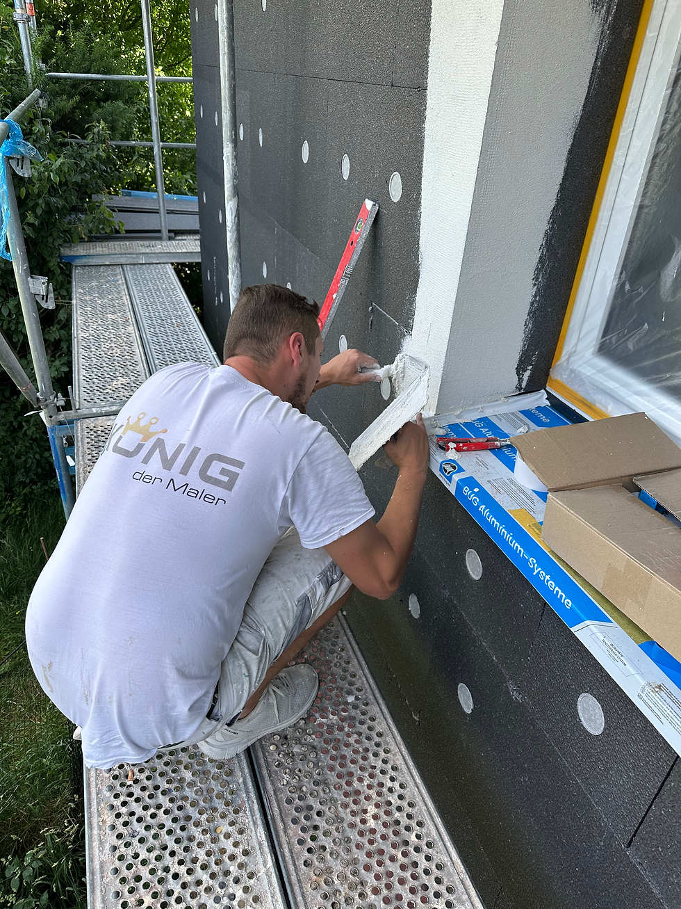 Mitarbeiter beim Verputzen der Fensternische des neu installierten WDVS
