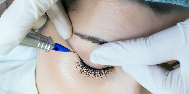 Permanent make-up tattoo. Cosmetologist applying permanent make up eyeliner, eyeliner tatt