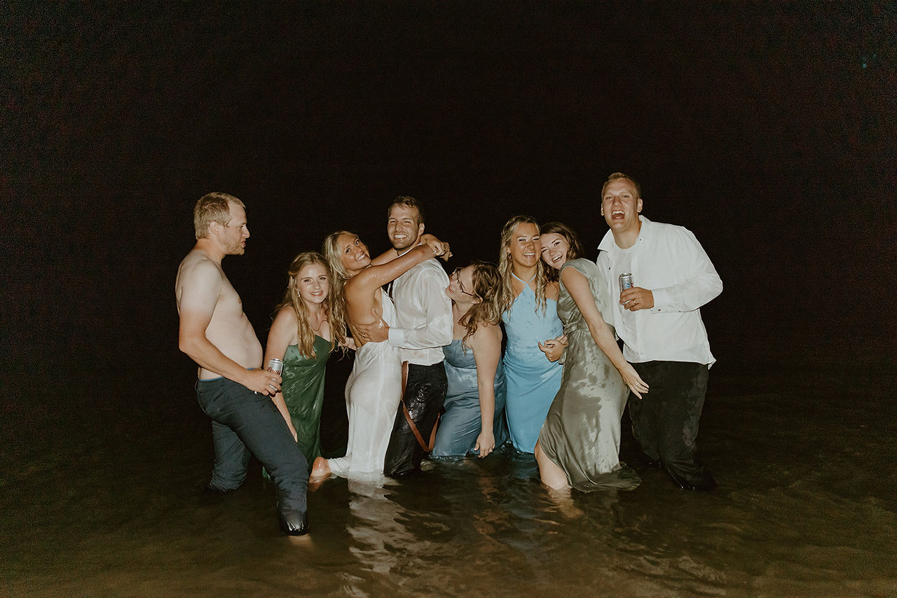 bridal party in the river with their clothes on
