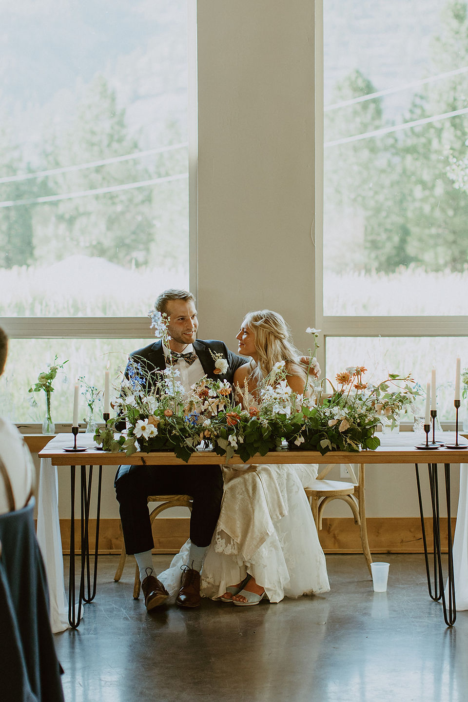 bride and groom at sweetheart table with wildflowers