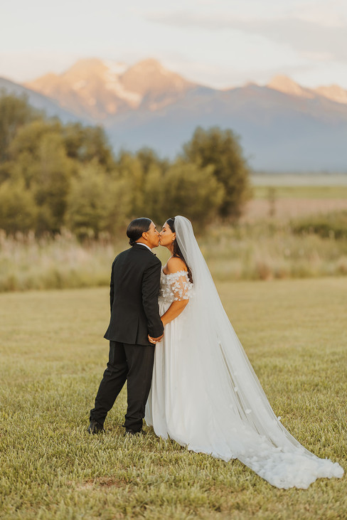 bride and groom kiss at sunset