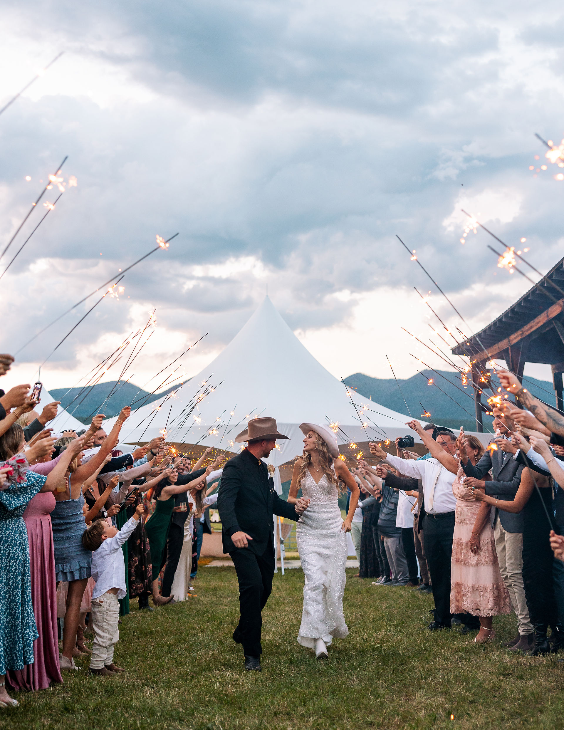 bride and groom walking through guests with sparklers