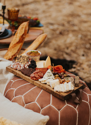 charcuterie board on a leather poof