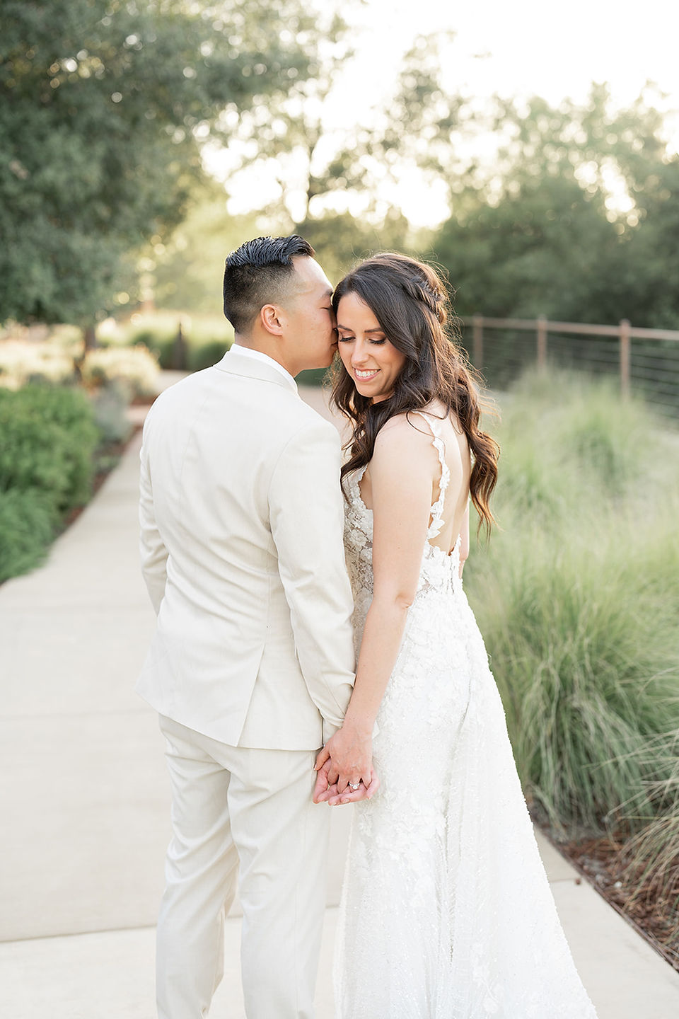 groom kissing bride's head