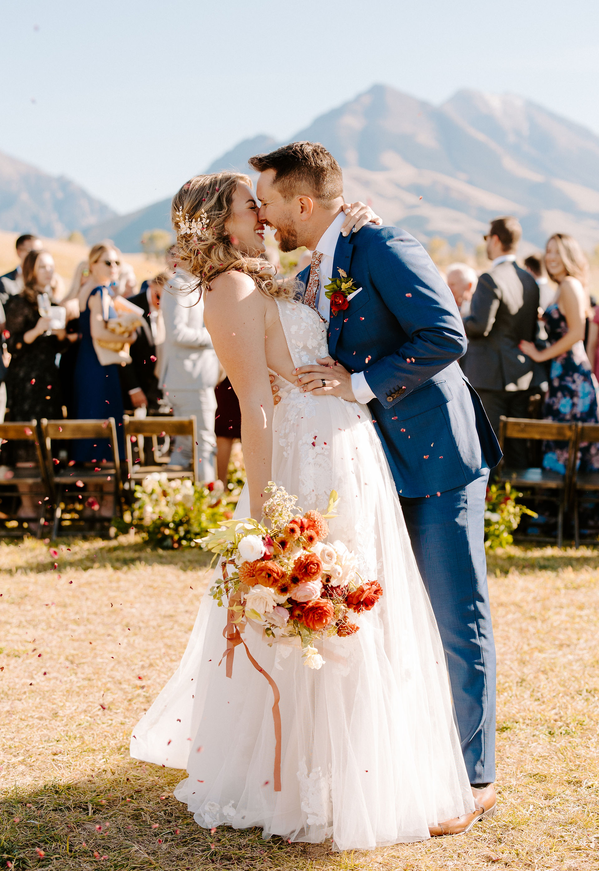 bride and groom kiss at the end of aisle