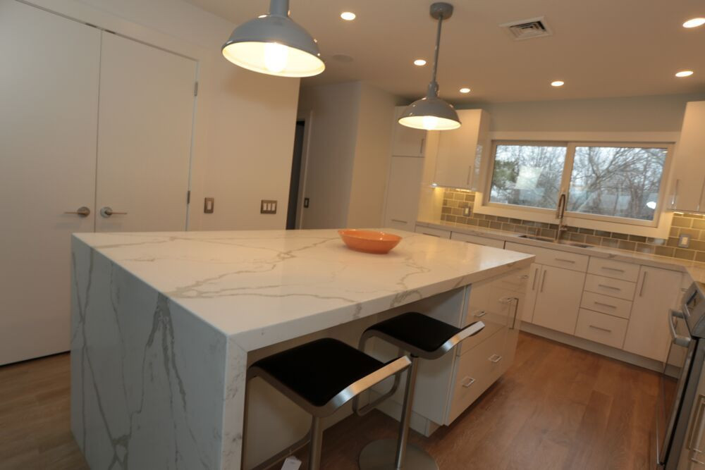 modern kitchen with stools and waterfall counter