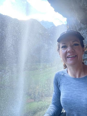 Author standing underneath waterfall
