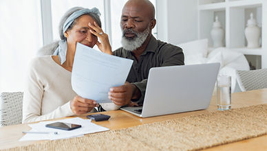 Black couple with laptop reviewing paper