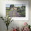 Thumbnail: Framed print above a table with flowers of an old farmhouse