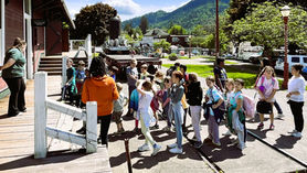 A group of school aged kids line up to visit the Depot