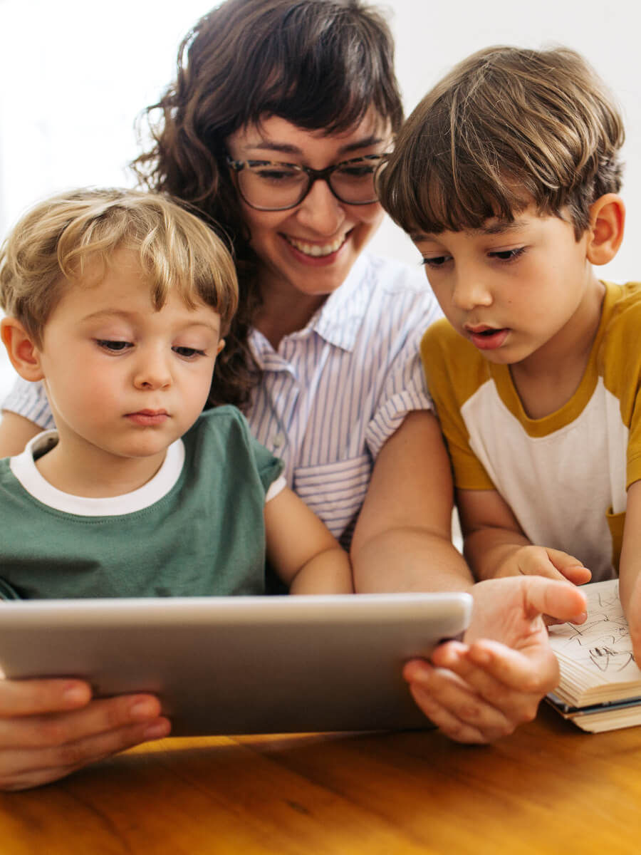 Šťastná matka se dvěma syny sleduje tablet
