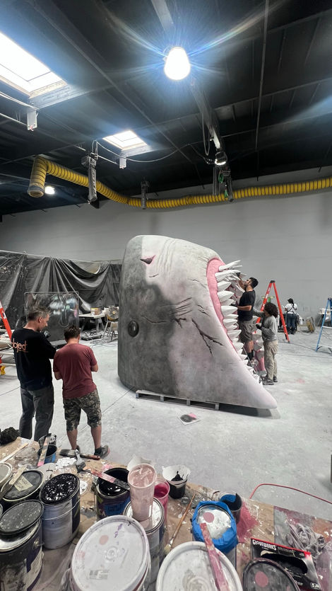 Experiential fabrication, scenic paint, sculpting, captivating, remarkable project, expert team, menacing Meg shark, intricate scenic paint work, artistry, detailed scenic design, awe-inspiring installation, experiential masterpiece, legendary Meg, face-to-face, thrill.